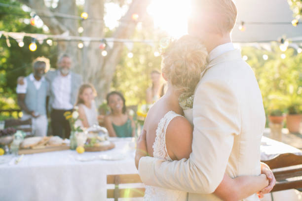 istock Young couple embracing in garden during wedding reception 544489925