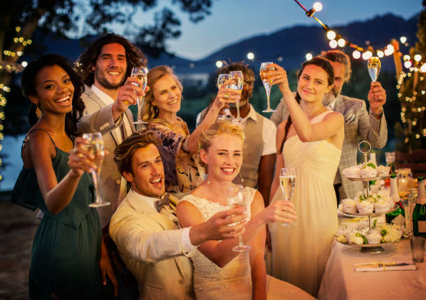 wedding guests toasting with champagne during wedding reception in garden - wedding champagne table wedding reception imagens e fotografias de stock