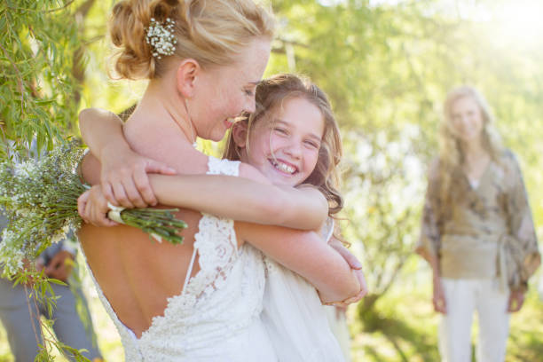 Bride embracing bridesmaid at wedding reception in domestic garden  free wedding stock pictures, royalty-free photos & images