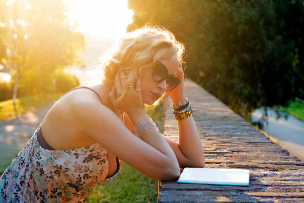 mujer relajada leyendo un libro - outdoors book reading accessibility fotografías e imágenes de stock