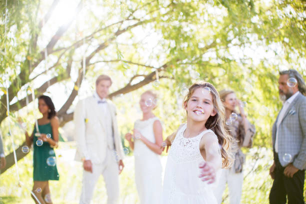 istock Bridesmaid playing with bubbles at wedding reception in domestic garden 544490365