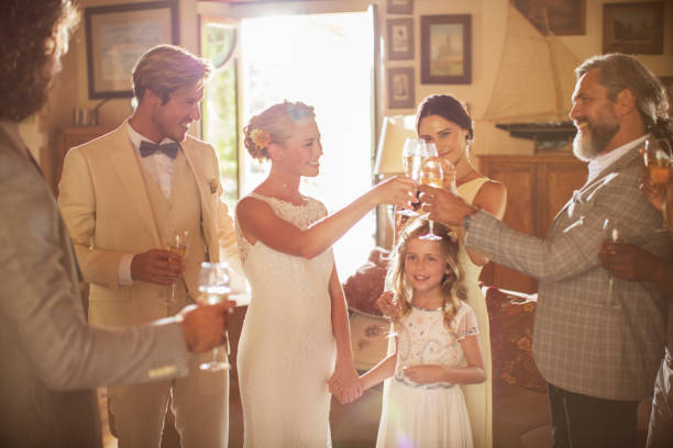 jovem casal e convidados brindando com champanhe durante a recepção do casamento em quarto doméstico - wedding dress wedding domestic room bride - fotografias e filmes do acervo