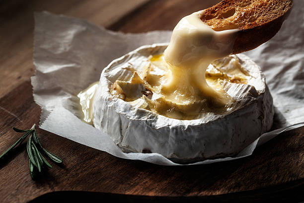 Baked camembert with toast and rosemary Baked camembert with toast and rosemary melting photos stock pictures, royalty-free photos & images