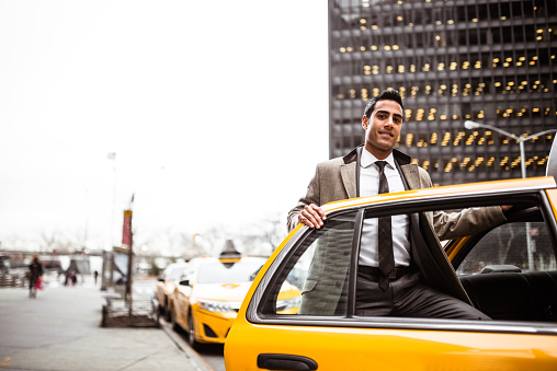Businessman Smiling at the Door of a Cab