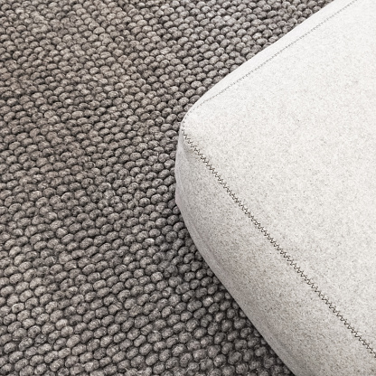 Close-up of a soft wool seat on gray carpet.