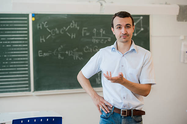 istock Young teacher near chalkboard in school classroom talking to class 544560546