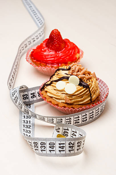 cupcakes with measuring tape on table - control room stockfoto's en -beelden