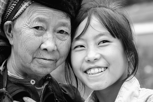Ha Giang, Vietnam - September 21st, 2015: Smile ethnic granddaughter headrest beside beloved grandmother expressed reverence, joy optimism in lives minority people in Ha Giang, Vietnam