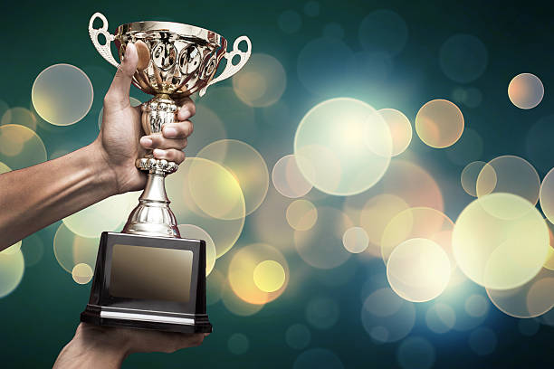 hand holding up trophy stock photo