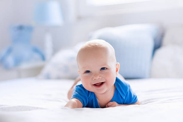 istock Cute baby boy in white sunny bedroom 544568252