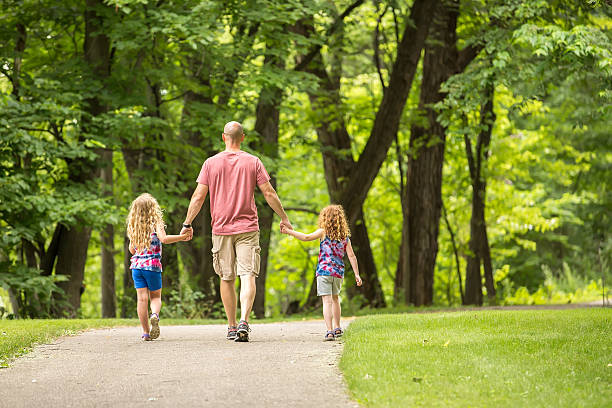 istock Father & Daughters Walking on Park Trail in Summer 544568264