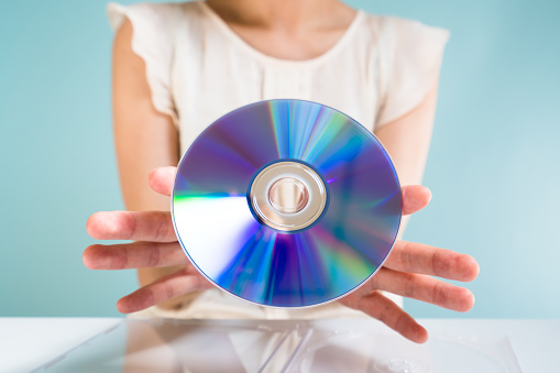 Asian woman holding DVD-ROM.