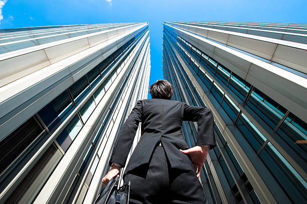 istock Businessman looking up at the high building, low angle 544569908