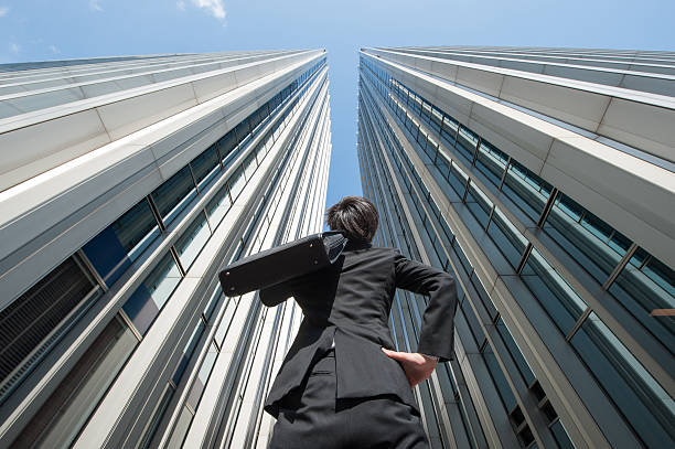 istock Businessman looking up at the high building, low angle 544569930