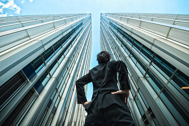 istock Businessman looking up at the high building, low angle 544569950
