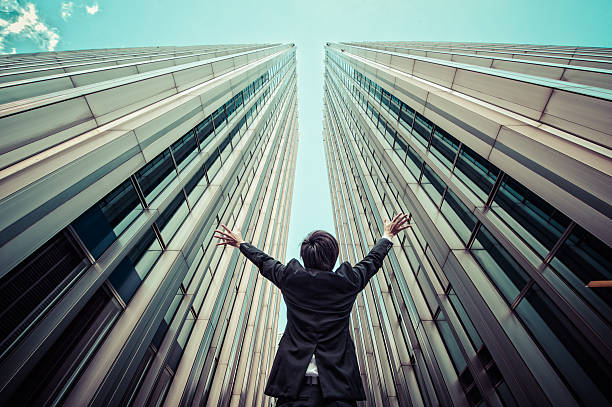 istock Businessman looking up at the high building, low angle 544569964
