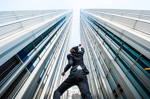 istock Businessman looking up at the high building, low angle 544569974