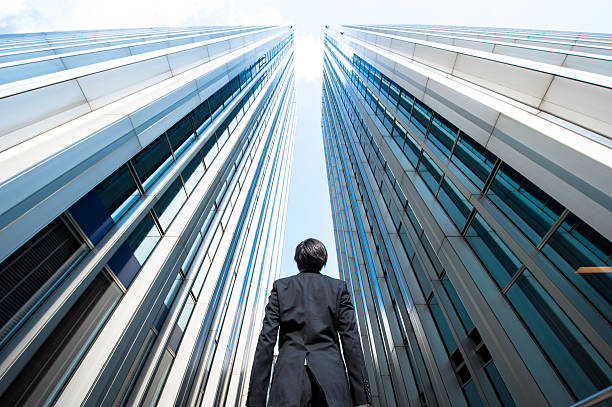 istock Businessman looking up at the high building, low angle 544570046