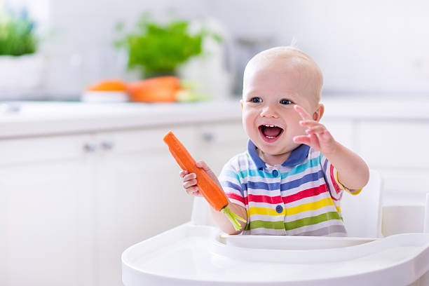 istock Little baby boy eating carrot 544572666