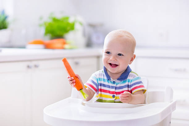 istock Sweet little baby eating carrot 544574322