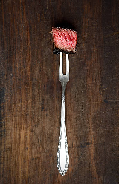 istock Slices of Medium rare grilled Steak Ribeye on meat fork 544575540