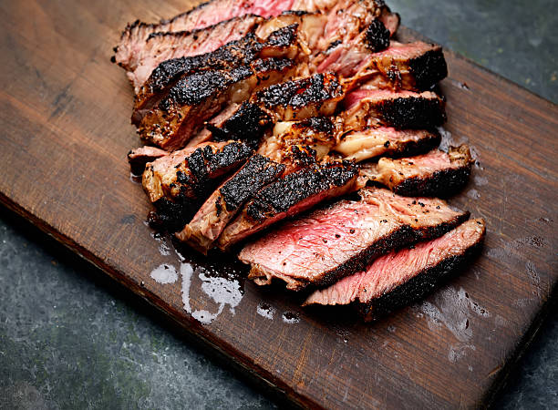 Sliced medium rare grilled Beef steak on wooden cutting board
