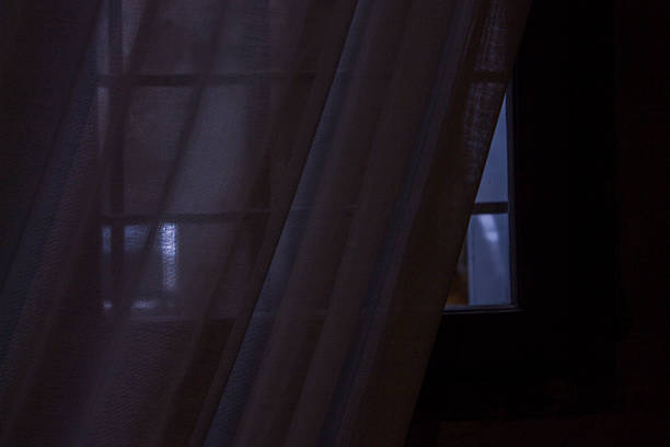 half-open window with curtain moved by the wind