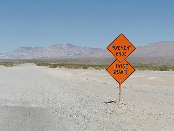 Traffic signs with warnings on road. Pavement ends and loose gravel signs on American road in Death Valley pavement ends sign stock pictures, royalty-free photos & images
