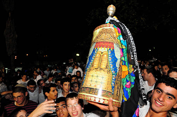 Celebrating Jewish Holiday Simchat Torah in a Synagogue Sderot, Israel - September 7, 2012: Israeli Jewish youth celebrate Simchat Torah by dancing with the scrolls of the Torah at a Synagogue in Sderot, Israel. Simchat Torah is a celebratory Jewish holiday that marks the completion of the annual Torah reading cycle. simchat torah photos stock pictures, royalty-free photos & images