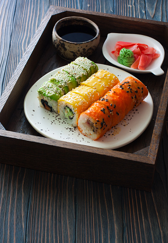 Set of sushi, ginger and bowl with soy sauce in wood tray