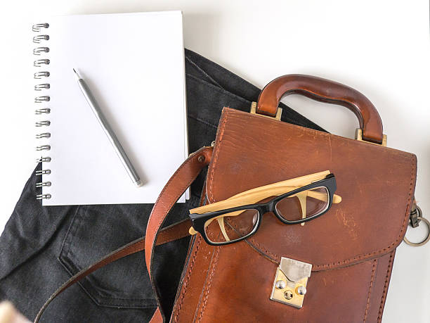 istock notebook  eye glasses pencil and leather bag on white background 544584092