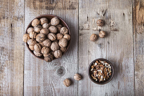 istock walnuts in a clay plate on a wooden background. top view 544584422