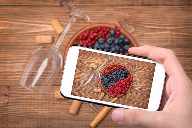 istock Hands taking photo wine glass with berries with smartphone. 544584594