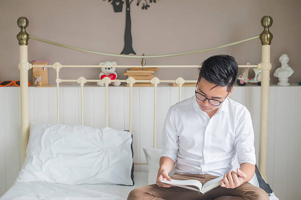 istock Serious young businessman sitting in bed reading book 544585394