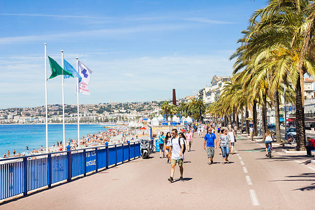 pessoas caminhando pela promedade des anglais, em nice, frança - city of nice france beach promenade des anglais - fotografias e filmes do acervo