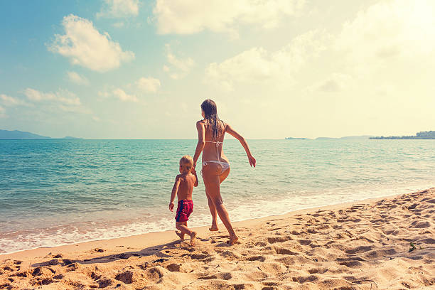 madre con bambini sulla spiaggia tropicale runnig - child exercising little boys toddler foto e immagini stock