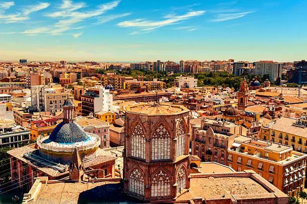 an aerial view of the roof of the Cathedral and the old town of Valencia, Spain, as seen from the Micalet, the belfry, highlighting the blue tiled dome of the Basilica de la Virgen de los Desamparados