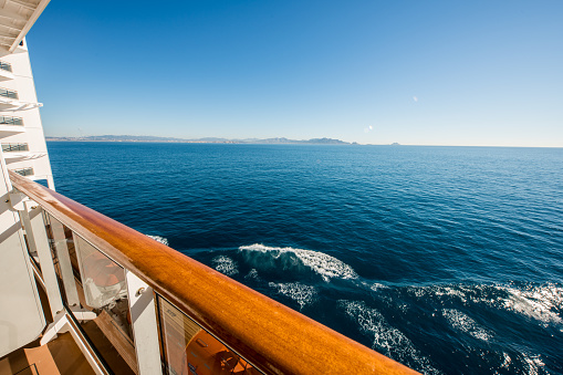 View of beautiful sea seen from cruise ship. Cropped image of nautical vessel is sailing on water during sunny day. It is against clear blue sky.