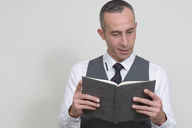 istock Studio portrait of man reading book 544591968