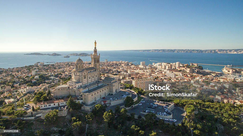 High angle view of cityscape by sea against sky High angle view of cityscape by sea. Notre Dame de la Garde in Marseille against clear sky. Buildings by seascape on sunny day. Marseille Stock Photo