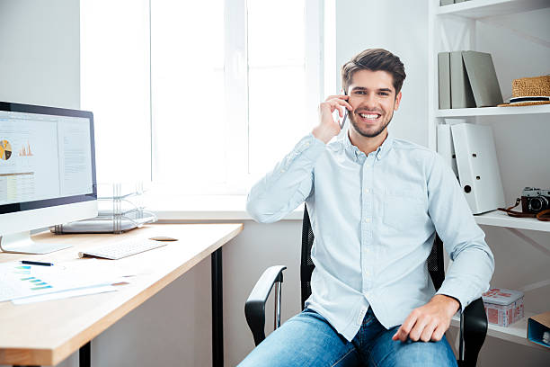 istock Businessman sitting at his workplace in office with mobile phone 544592352