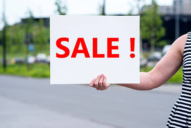 istock woman holding a sale sign 544593680