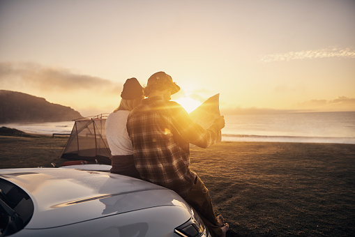Shot of a young couple stopping by the beach to look at a map while on a roadtrip