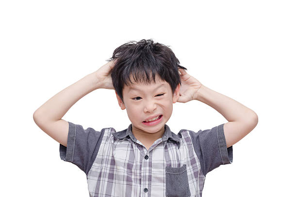 Young boy scratching his scalp stock photo