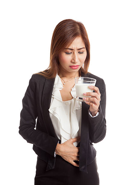 femme asiatique, boire un verre de lait a maux d'estomac - got milk photos et images de collection