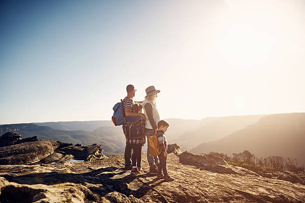 Hiking is better when you share it your family Shot of a young family going on a hike in the mountains family camping stock pictures, royalty-free photos & images