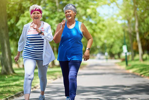 Choose your fitness goals and get going Shot of two elderly friends enjoying a run together outdoors active seniors stock pictures, royalty-free photos & images