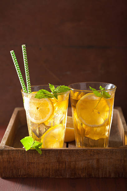 ice tea with lemon and mint on dark rustic background