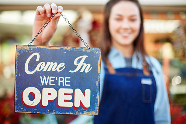 istock Smiling florist holding up sign saying come in we're open 544601894