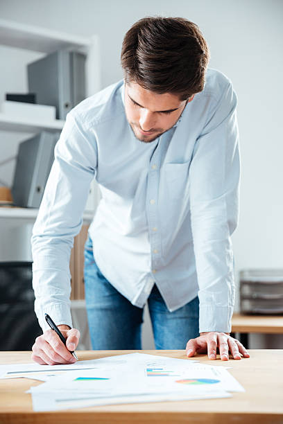 istock Serious young businessman writing on the table in office 544602180